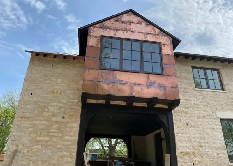 Copper metal panel facade on a stone building for Roof Repair in University Heights